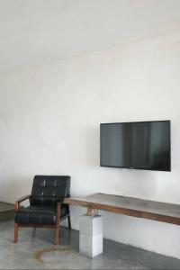 a black leather chair and a television on a wall at Daban Six Guest House in Nanwan
