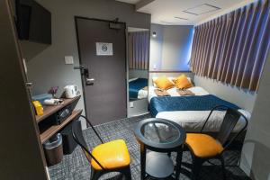 大阪的住宿－Hotel S-Presso North，酒店客房带一张床、一张桌子和椅子