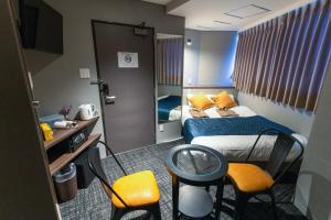 a hotel room with a bed and a table and chairs at Hotel S-Presso North in Osaka