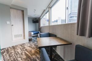 a room with a table and chairs and a window at Hotel S-Presso North in Osaka