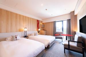 a hotel room with two beds and a television at Kyoto Tokyu Hotel in Kyoto