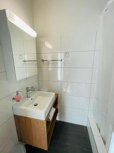 a white bathroom with a sink and a mirror at Hotel Rössli in Basel