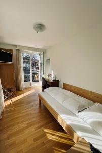 a bedroom with a bed and a desk and a window at Hotel Rössli in Basel