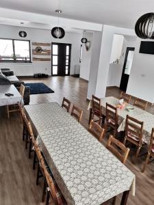 a dining room with tables and chairs and a room at Izvorul Prigoanei in Tău Bistra