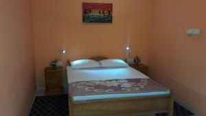 een slaapkamer met een bed en een foto aan de muur bij Basilico Homestay in Kegalle