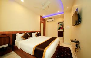 a hotel room with a bed and a television at Hotel Golden Palace in Kolkata
