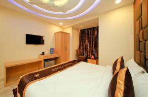 a hotel room with a bed and a tv at Hotel Golden Palace in Kolkata +69 photos