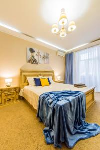 een slaapkamer met een groot bed met een blauwe deken erop bij 2к квартира на Басейній, ТРЦ Гуллівер in Kiev