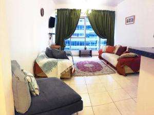 un soggiorno con divano e finestra di Octavius Holiday Home, Large 2 Bedroom Apartment near Global Village & Outlet Mall a Dubai