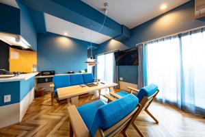 a dining room with blue walls and a table and chairs at VILLA KOSHIDO kotoni in Sapporo