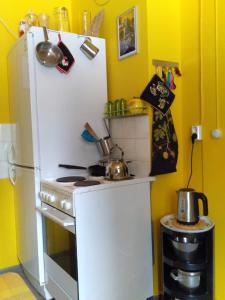 een kleine keuken met een witte koelkast en een fornuis bij Art House & Sculpture Garden in Mänttä