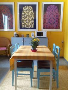 mesa de comedor con sillas y pinturas en la pared en Art House & Sculpture Garden, en Mänttä