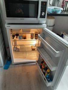 an open refrigerator with a microwave on top of it at Hooibeemd in Assen