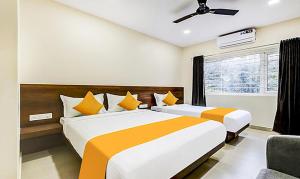 a bedroom with two beds and a window at FabHotel Rove Inn & Suites Jalahalli West in Chik Bānavar