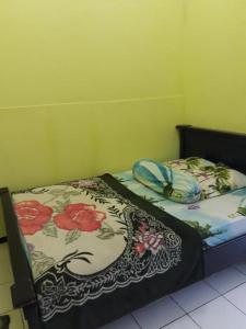 a bedroom with two beds with flowers on them at Kampoeng Tourist Homestay in Licin