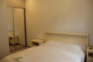 une chambre avec un lit blanc et un miroir dans l'établissement Jurincom apartments Kralovska Vyhlidka, à Karlovy Vary