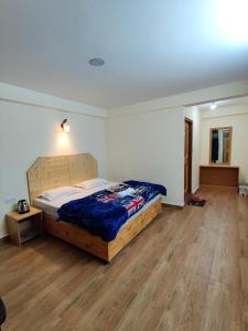 a bedroom with a bed and a wooden floor at Uncle Nomad in Manāli