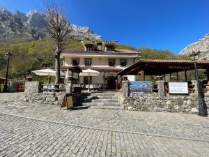 ein Gebäude mit einem Restaurant vor einem Berg in der Unterkunft Hostal La Ruta in Caín