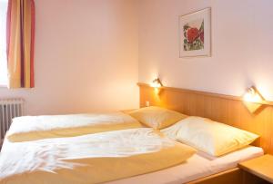 a bedroom with a bed with two pillows on it at Antares am See in Maurach
