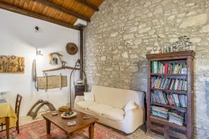 een woonkamer met een witte bank en een boekenplank bij Baglio Anastè in Buseto Palizzolo