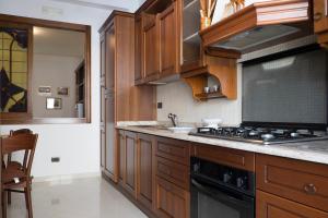 a kitchen with wooden cabinets and a stove top oven at Minori Apartment in Minori