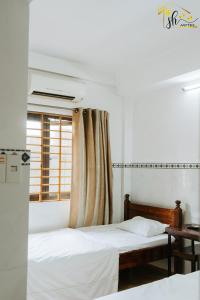 a bedroom with two beds and a window at SH Hotel in Hue
