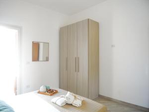 トッレ・デル・オルソにあるAppartamenti Via Corfù - Le vie di Omeroのベッドルーム(木製キャビネット、ベッド付)