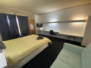 a hotel room with a bed and a desk at Capri Motel in Balranald