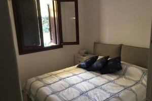 ein Schlafzimmer mit einem Bett mit zwei Kissen darauf in der Unterkunft Bilocale ristrutturato con piscina. Spiagge vicine. in Porto Rotondo