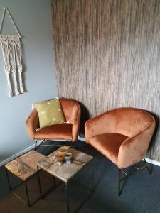 a living room with a couch and a chair at Bed and Breakfast Kik en Bun in Katwijk aan Zee