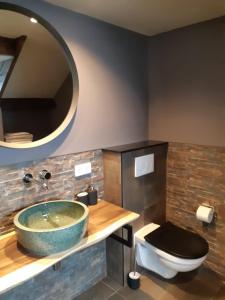 a bathroom with a large bowl sink and a toilet at Bed and Breakfast Kik en Bun in Katwijk aan Zee