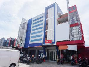 a building with motorcycles parked in front of it at OYO 90305 De Umbrela Mansion Syari'ah Ciputat in Tangerang