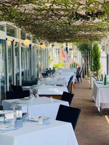 a restaurant with white tables and chairs and windows at Hotel Playa Canet in Canet de Berenguer