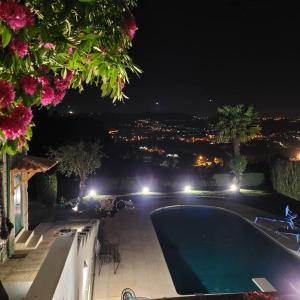uma piscina à noite com vista para a cidade em Casa de Ladrido em Felgueiras