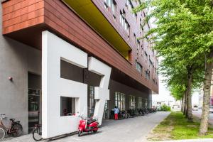 un edificio con uno scooter rosso parcheggiato fuori di Houthavens Apartments ad Amsterdam