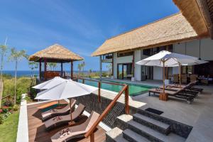 a resort with a pool and chairs and umbrellas at Villa Lakshmi in Temukus