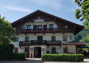 een groot wit gebouw met een gambrel dak bij Gasthof Tiroler Hof in Bad Feilnbach