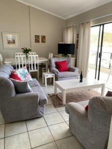 Sala de estar con 2 sofás y mesa en Herolds Bay Accommodation - Smalstaan Upstairs, en Herolds Bay
