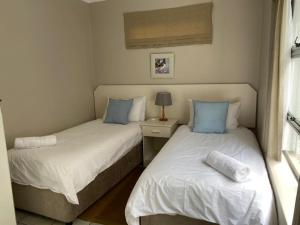 dos camas sentadas una al lado de la otra en una habitación en Herolds Bay Accommodation - Smalstaan Upstairs en Heroldsbaai