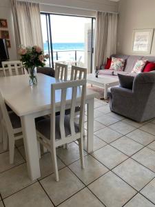 a living room with a table and chairs and a couch at Herolds Bay Accommodation - Smalstaan Upstairs in Herolds Bay