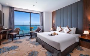 a hotel room with a large bed and a large window at Vesna Hotel in Nha Trang