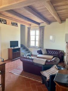 een woonkamer met leren banken en een televisie bij La Famulenta 17 in Grazzano Badoglio