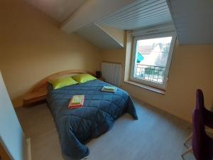 a bedroom with a bed with yellow pillows and a window at L Etoile d'Argent in Varangéville