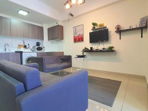 a living room with a couch and a tv at HYVE SOHO Cyberjaya by BeeStay Management in Cyberjaya