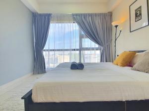 a bedroom with a large bed with a large window at HYVE SOHO Cyberjaya by BeeStay Management in Cyberjaya