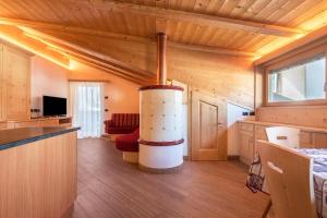una sala de estar con una gran chimenea en una casa de madera en Villa Doris en Canazei