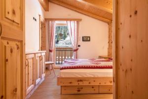 1 dormitorio con cama y ventana en Villa Doris en Canazei