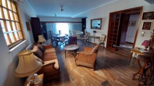 een woonkamer met een bank, stoelen en een tafel bij METROPOLITAN Macview -2 in Piraeus