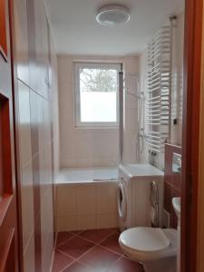 a bathroom with a tub and a toilet and a window at Mieszkanie Nad Popradem INPIW03 in Piwniczna
