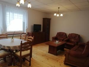 - un salon avec une table, des chaises et une télévision dans l'établissement Mieszkanie Nad Popradem INPIW03, à Piwniczna-Zdrój